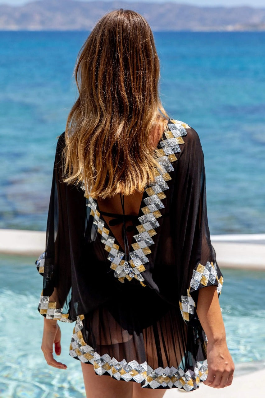 This product is a bright yellow sheer beach cover-up tunic designed with a playful.