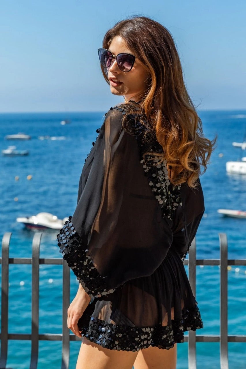 This product is a bright yellow sheer beach cover-up tunic designed with a playful.