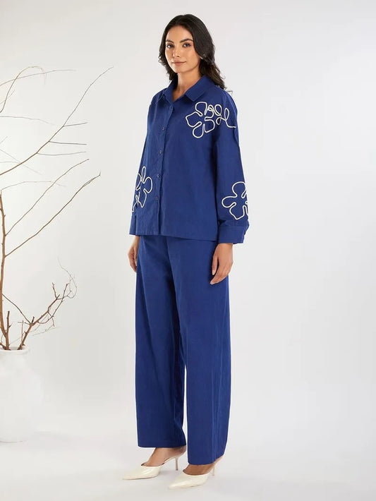 Trousers: High-waisted with a wide-leg cut, matching the fabric and color of the shirt for a cohesive look.