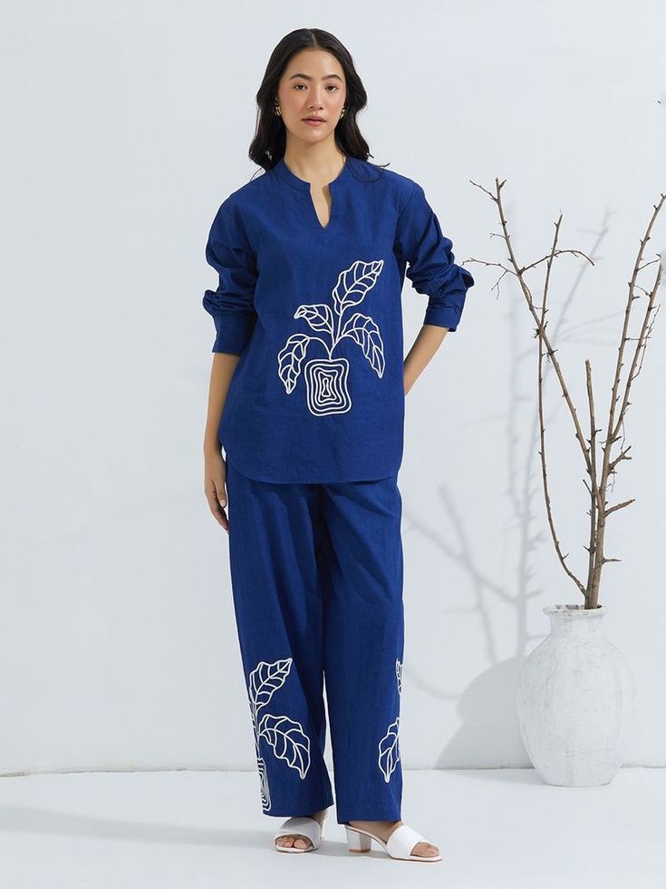Trousers: High-waisted with a wide-leg cut, matching the fabric and color of the shirt for a cohesive look.