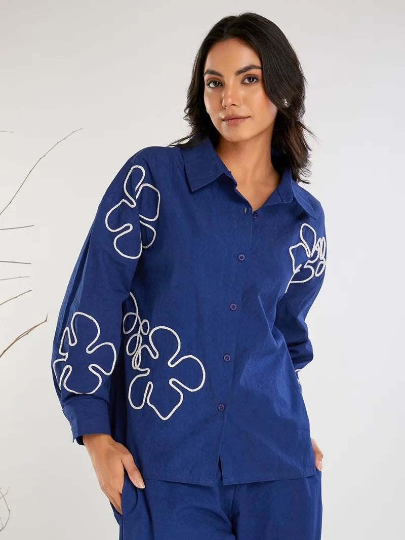 Trousers: High-waisted with a wide-leg cut, matching the fabric and color of the shirt for a cohesive look.