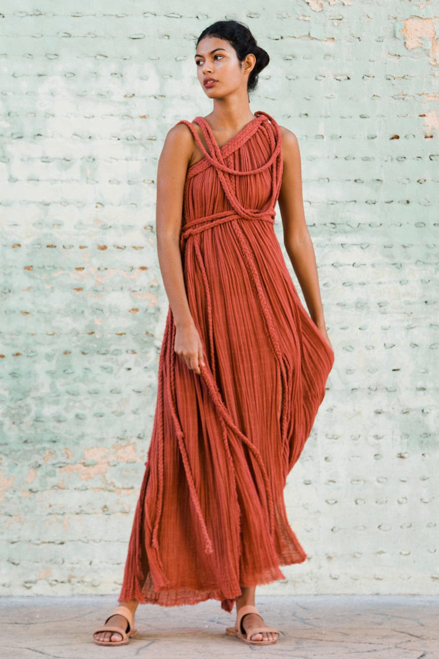 rust-orange bohemian maxi dress with a flowy, textured silhouette and unique rope detailing. It’s both effortless and artistic, perfect for someone who wants to make a natural yet bold statement.