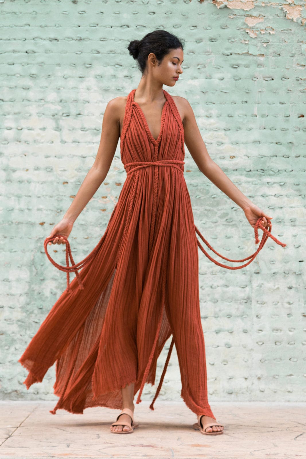 rust-orange bohemian maxi dress with a flowy, textured silhouette and unique rope detailing. It’s both effortless and artistic, perfect for someone who wants to make a natural yet bold statement.
