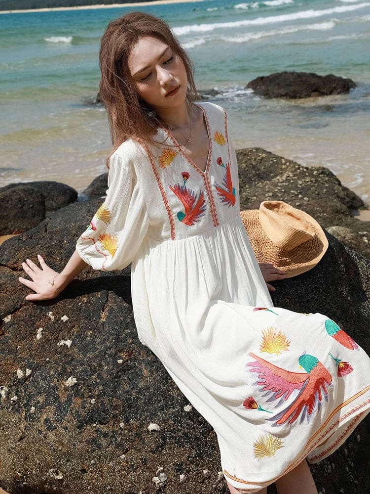 bohemian-style beach dress. It is made from a flowy, lightweight fabric in an off-white or cream color, perfect for warm weather.