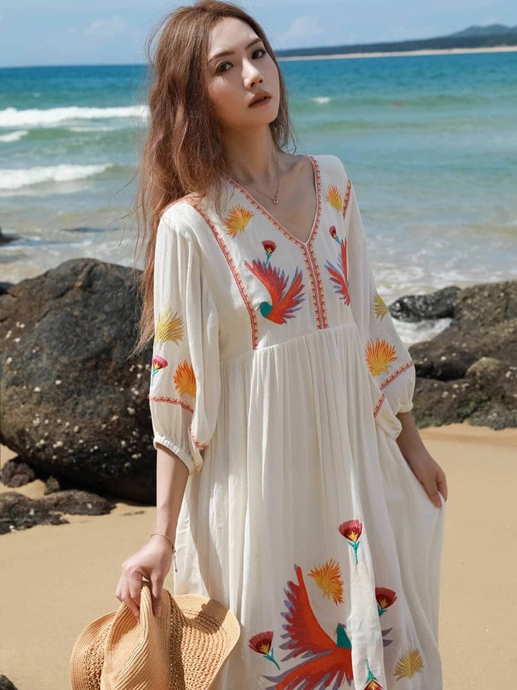 bohemian-style beach dress. It is made from a flowy, lightweight fabric in an off-white or cream color, perfect for warm weather.