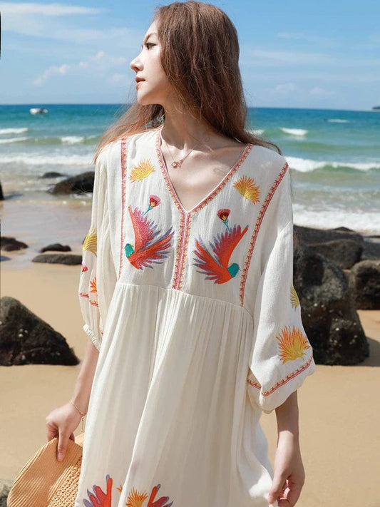 bohemian-style beach dress. It is made from a flowy, lightweight fabric in an off-white or cream color, perfect for warm weather.